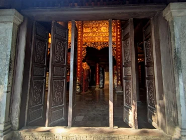 Ornate temple doors opening onto a golden-lit inner hall