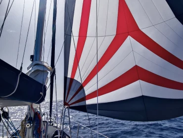 A spinnaker sail filled with wind aboard a sailboat mid-ocean
