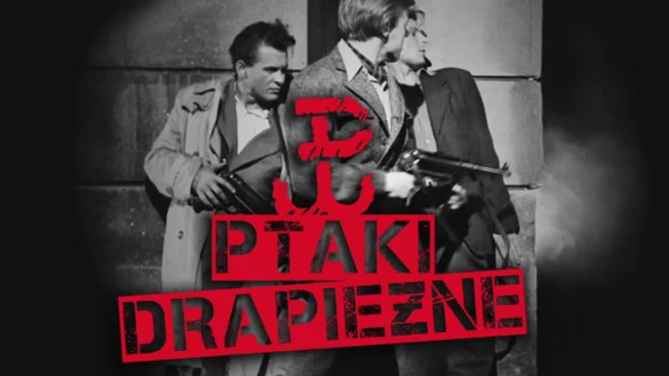 Video thumbnail — a black-and-white film still of men in a doorway, overlaid with the red grunge title &ldquo;Ptaki Drapieżne.&rdquo;